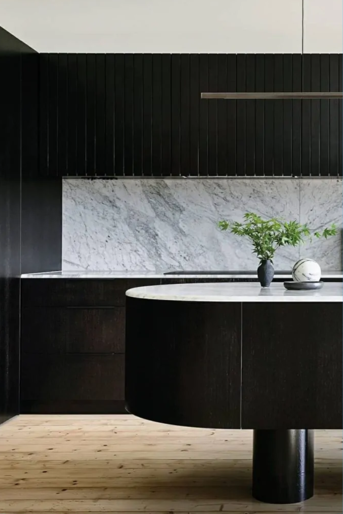 image of a light filled kitchen with a bold black island