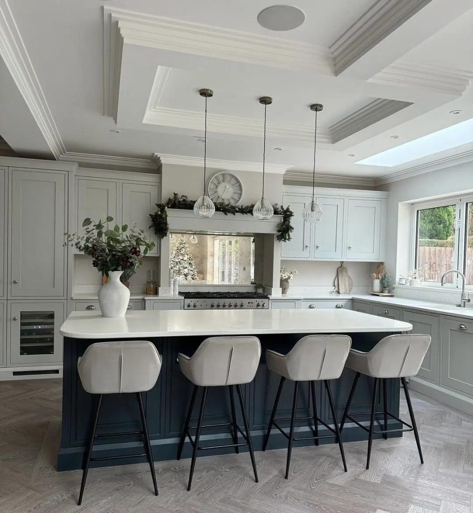 Soft sage cabinetry nails the muted earth tone—the navy island is the one element we’d lighten.
